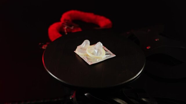 Condoms spinning on a black surface with red lighting effects for creative visual display