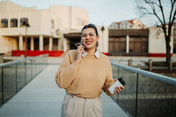 Obraz premium Young caucasian businesswoman drink coffee on the work break and use cellphone 