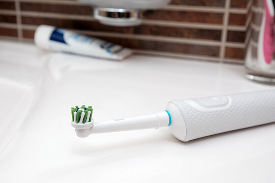 Close-up a modern electric toothbrush on the bathroom sink.