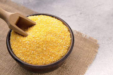 Raw cornmeal in a bowl on a gray tiled table
