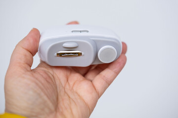 Close-up of an electric nail clipper in hand, modern personal care technology, highlighting compact design and functionality, modern gadget for personal grooming