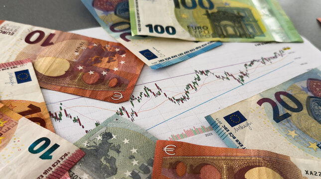 The concept of the fall and growth of the euro exchange rate. One hundred euro on a blue chart background.