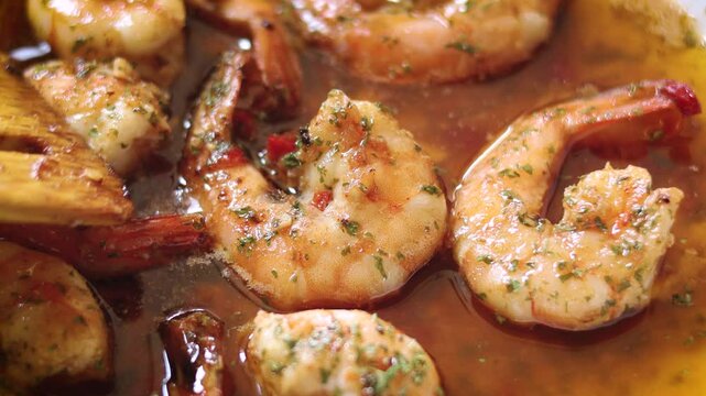Delicious close-up of  Gambas al Ajillo &mdash; juicy prawns cooked in garlic-infused olive oil with a touch of chili and parsley