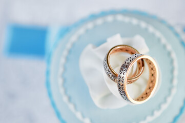 Close-Up of Wedding Rings on a Cake with Blue and White Details