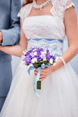 Bride Holding Purple Bouquet in Wedding Ceremony Close-Up..