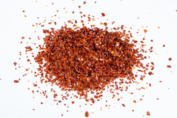Hot chili peppers crushed and dried, natural seasoning on a white background isolate top view.