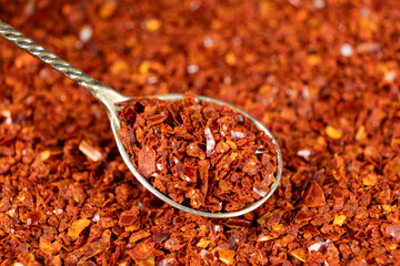 Crushed red hot chili pepper natural seasoning in a spoon