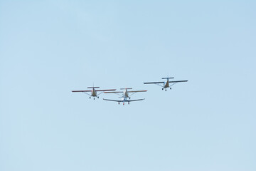 Four small planes against the blue sky.