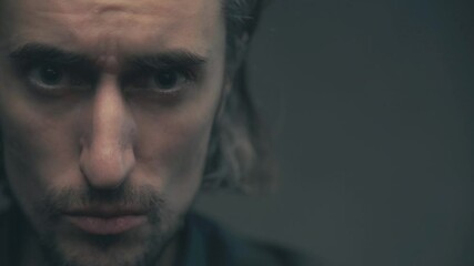 Close-Up of a Man's Intense Expressions: Contemplation and Tension in Dramatic Lighting