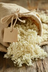 Dried elderflower blossoms in linen bag, tied label with rustic string, top-down botanical layout