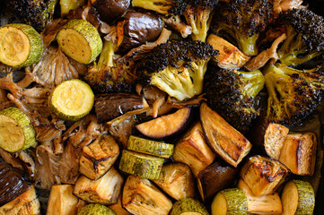 Oven-roasted vegetables: broccoli, zucchini, eggplant, and oyster mushrooms. Healthy, colorful dinner, perfect for family meals. Nutritious plant-based food, vegetarian cuisine