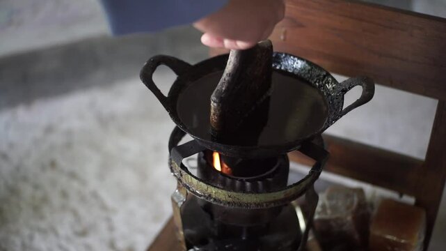 Batik Artist Dipping Canting into Hot Wax for Pattern Making