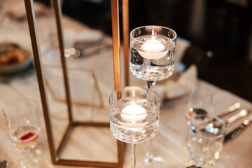 A graceful candle stand, glowing softly, casting warm light and quiet charm. Each flame adds a touch of magic to the atmosphere of love and celebration