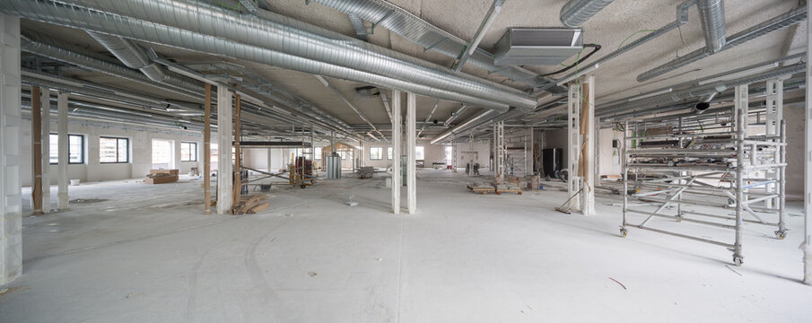 Spacious office interior under renovation with industrial ducts
