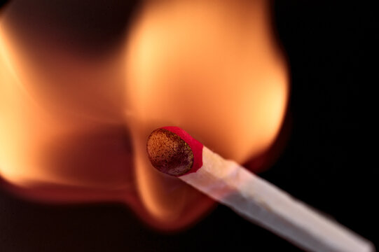 Striking matchstick engulfed in vibrant flame close up