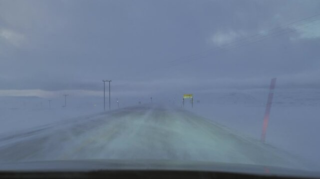 car driving in the storm on the snowy road pov,inside vehicle point of view,north cape norway winter time