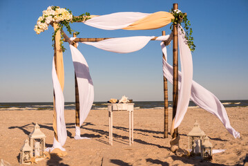 Wedding arch, altar for ceremony on the beach against the sea. Wedding in sea style. Sand and...