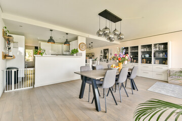 A stylish dining room featuring a contemporary table and chairs, elegant lighting, and floral arrangements that enhance the inviting atmosphere.
