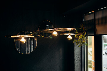 Stylish lamps in a dark restaurant interior, close up.