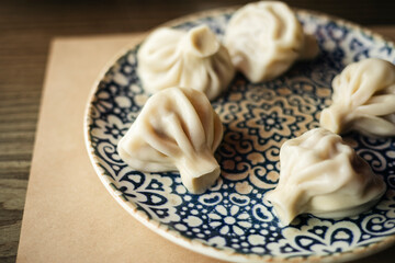 Home Georgian cuisine in a restaurant: khinkali on a patterned plate.