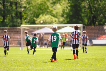 Group of Boys Play Football Game Together. School Kids in Two Soccer Teams Kicking Ball During...