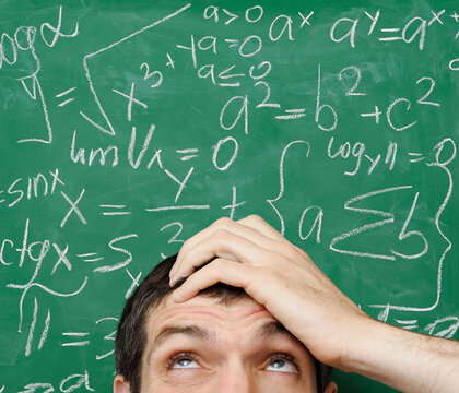 Confused man in front of math formula written on a chalkboard