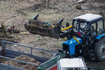 The unloading of construction debris into the van emphasizes the role of machinery in creating a...