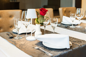 Restaurant. A table set for dinner. Cutlery, glasses and napkins on a table covered with a white tablecloth