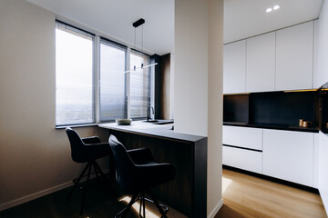 This modern kitchen features stylish bar seating that enhances the space and invites light