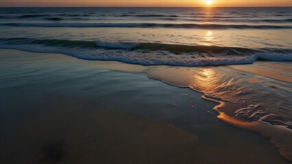   A calm ocean at sunrise with gentle waves lapping at the sh