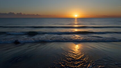   A calm ocean at sunrise with gentle waves lapping at the sh