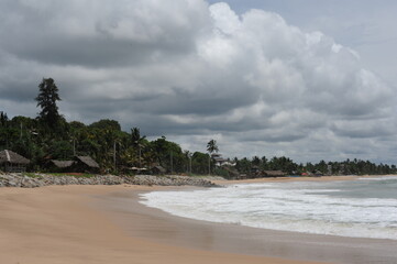 Indian Ocean rocku coast with rocks and high waves and blue sky and white clouds on a sunny day in Tangalle, Sri Lanka
