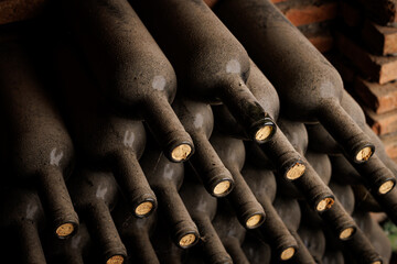Collection of Vintage Wine Bottles in a Cellar. A close-up view of rows of dusty wine bottles...