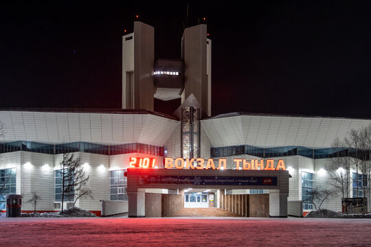 Tynda railway station, Amur region, Russia - January 21, 2024. Night view of the station building. Text in Russian "Tynda Station" and "Bright travels in the New Year!". Baikal-Amur Mainline (BAM).
