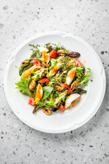 A colorful salad featuring mixed greens, cherry tomatoes, and soft-boiled eggs. This dish is both nutritious and visually appealing, perfect for a light meal or appetizer.