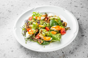 A colorful salad featuring mixed greens, cherry tomatoes, and soft-boiled eggs. This dish is both nutritious and visually appealing, perfect for a light meal or appetizer.