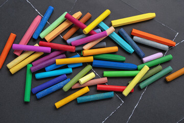 Colorful oil pastel crayons for drawing on sheets of black paper