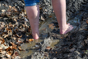 A person is walking barefoot in moody area, connecting with nature and enjoying the sensory experience of the earth beneath their feet.