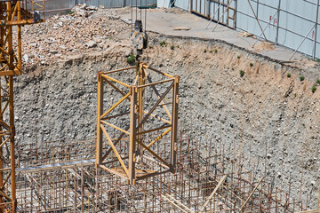 A construction crane lifts an additional crane section on a hook to increase the height....