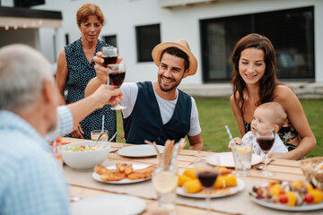 Family toasting with wine during spring family barbecue.