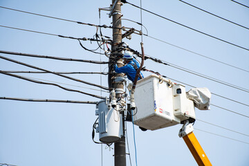電柱の電気工事をする作業員