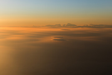 Golden-hued clouds at sunset, viewed from the plane