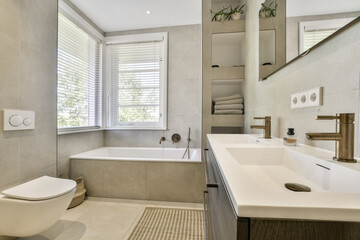 A sleek, modern bathroom featuring a bathtub and a stylish vanity, complemented by natural light and contemporary fixtures for an elegant ambiance.