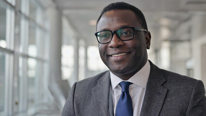 Fototapeta premium A man wearing a suit and tie smiles directly into the camera