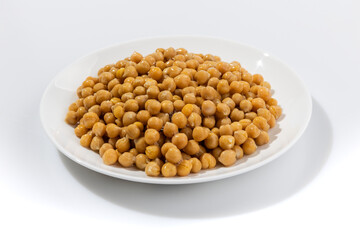 Boiled canned chickpeas in a ceramic bowl on white background.