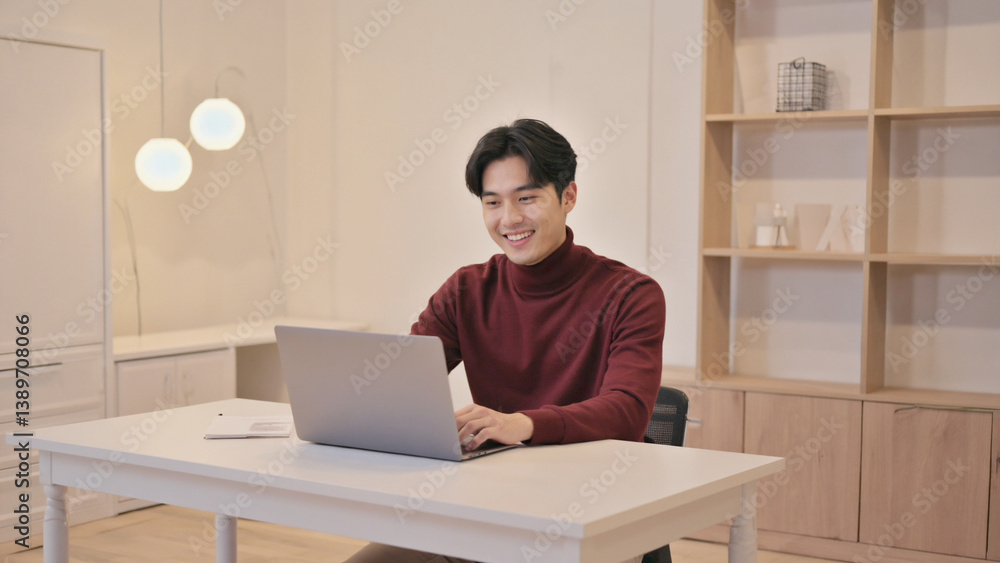 Poster a person sitting at a desk using a laptop computer, possibly for work or study