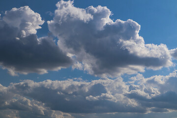 Light gray airy clouds in the blue sky on a sunny day