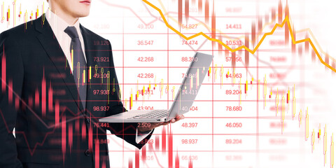 Businessman in suit with laptop overlaid by crashing stock charts, red arrows, and downward lines...