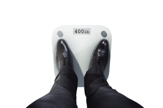 Man in suit and black shoes standing on a digital weight scale reading 400 lb, isolated on clean white background, concept of obesity or health