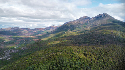 Fototapeta premium Dark lakes between the mountains of Tasmania on a cloudy day, seen from above